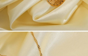 Close-up of gold eight-pointed star pendant with black diamond on a water wave chain