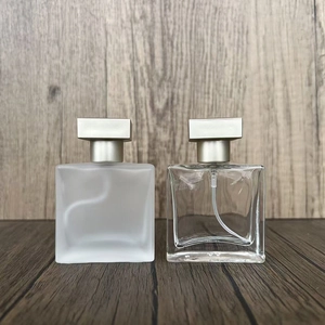 Detail of square glass perfume bottles in frosted and clear finishes with metal caps