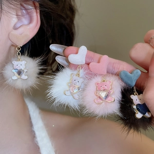 Detail of plush pompom bear earrings with sparkling crystal heart in multiple colors