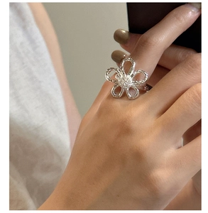 Close-up of S925 silver hollow floral ring on model finger with elegant petals