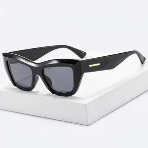 Oversized black cat-eye sunglasses with thick frames and gold metal accents for women