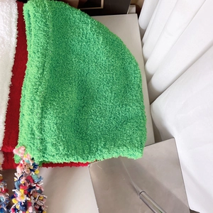 Macro detail of plush sherpa fabric texture and colorful tassel fringe on winter hat