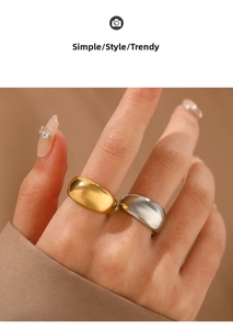 Polished gold and silver wide curved stainless steel rings shown on hand