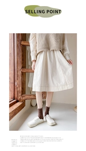 Detail of brown ruffle edge cotton socks with floral embroidery in a retro style