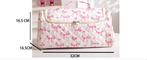 Detailed view of quilted makeup bag with pink bow pattern and 32x16.5x16.5cm dimensions