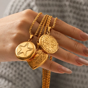 Colliers vintage français plaqués or 18K avec pendentifs en relief sur un pull gris