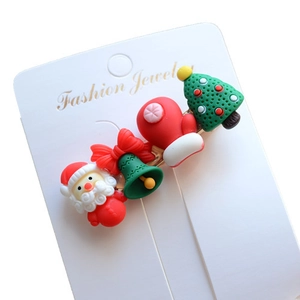Detailed view of Christmas hair clips with resin Santa, bell, and tree on card