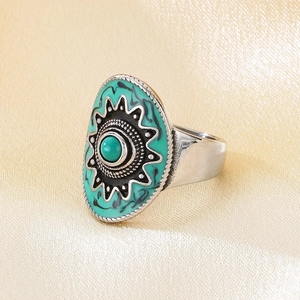 Detailed close-up of a vintage bohemian oval ring with turquoise stone and beaded edges