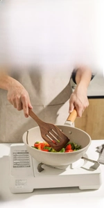 Macro detail of teak wood slotted spatula with three slots for non-stick pan cooking