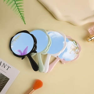 Close-up of four floral hand mirrors in pastel colors on a professional studio setup