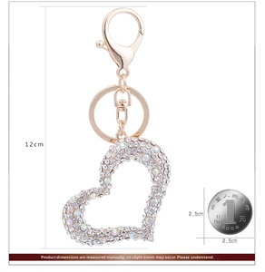 Detailed size view of sparkling rhinestone heart keychain with coin for scale