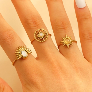 Macro shot of gold sunbeam rings with opal-like gems and twisted rope band details