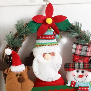 Christmas wreath with plush Santa, Snowman, and Reindeer figurines on a natural rattan base