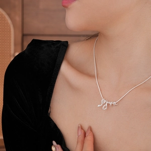 Dettaglio della collana con ciondolo a serpente argento su modella con velluto nero