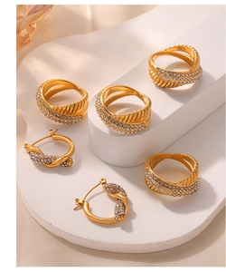 Detailed set of gold plated titanium rings and earrings with sparkling diamond accents