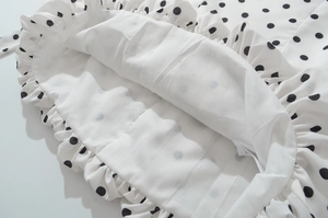 Détails de la doublure double couche et du motif à pois noirs sur la robe en gros plan
