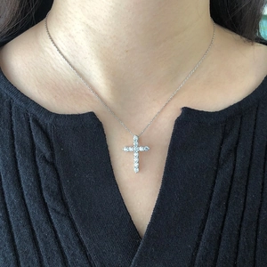 Close-up of S925 silver cross pendant necklace with zircon stones worn by a model