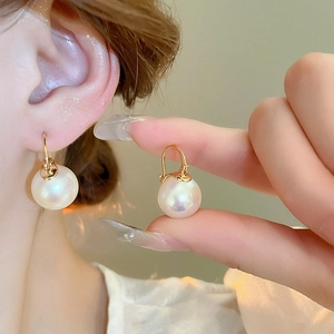 Gros plan détaillé d'une perle haute brillance montée sur un crochet d'oreille plaqué or