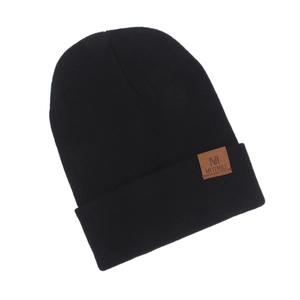 Close-up shot of a black knitted beanie hat featuring a brown leather brand patch.