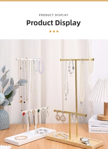 Detail of double-layer metal jewelry stand with wooden base for earrings and necklaces