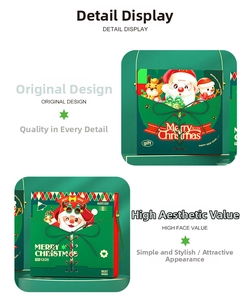 Detail of green Christmas gift box featuring Santa and reindeer illustrations with black bow