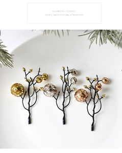 Close-up of sparkling Christmas berry picks in gold and silver on white ceramic plate