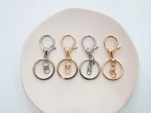 Dettaglio set di portachiavi con moschettone in argento oro e oro rosa su ceramica