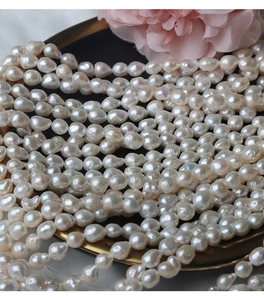 Close-up of irregular baroque freshwater pearls with rainbow luster on a gold tray