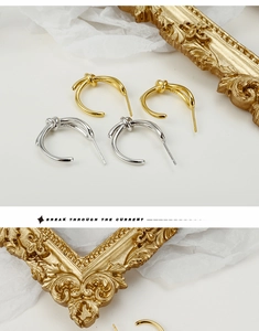 Dettaglio di orecchini a nodo in argento 925 con finiture in oro e argento