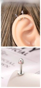 Macro detail of F136 titanium labret stud with triangle pink gemstone for cartilage piercing