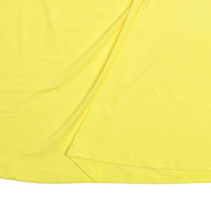 Détail de l'ourlet en tissu jaune montrant une couture à double aiguille de qualité