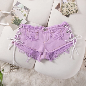 Dettaglio degli shorts mini in denim viola con lacci laterali bianchi e orli sfrangiati