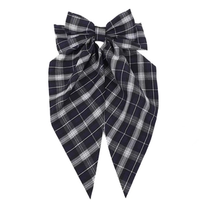 Detail of navy blue plaid bow hair clip with classic checkered pattern and fabric texture