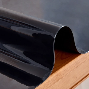 Detail of glossy black silicone desk mat showing thick flexible material and heat resistance