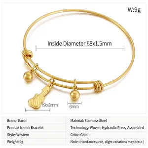 Detail view of golden stainless steel expandable bangle with guitar and bead charms