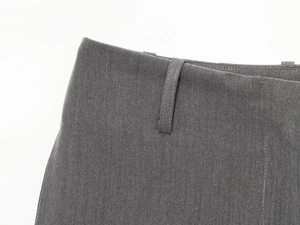 Close-up of high-quality dark grey suit trousers fabric with belt loop and neat stitching