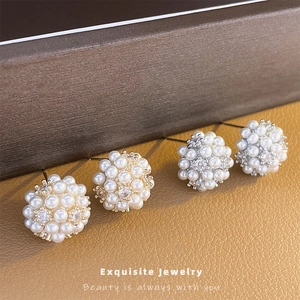 Elegant cluster pearl stud earrings with sparkling zircon center on brown leather