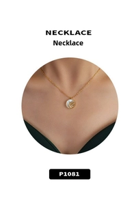 Macro detail of a gold 18k necklace featuring a round pearl shell with a golden rose