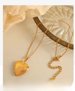 Detailed view of vintage gold heart locket necklace with floral engraving and O-chain
