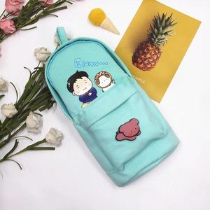 Detailed macro view of a mint green backpack-shaped canvas pencil case with cute cartoons