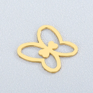 Macro view of a gold-tone hollow butterfly pendant charm with a heart-shaped center