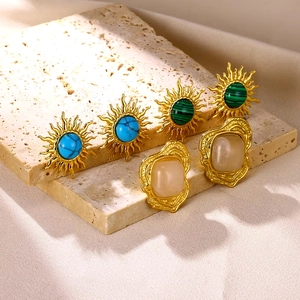 Vintage gold sunflower earrings set with turquoise and malachite stones on stone background