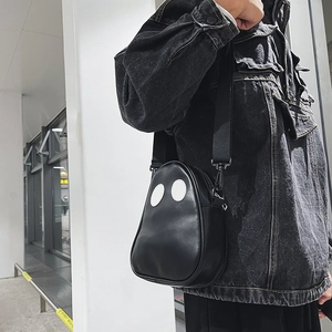 Side view of trendy black PU leather ghost bag with white dot accents on model