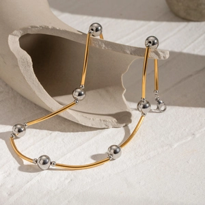 Detailed shot of two-tone stainless steel tube and bead necklace with lobster clasp