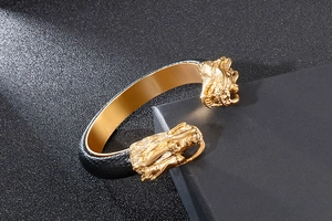 Detailed close-up of a double dragon head bracelet in gold and black stainless steel
