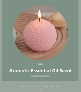 Detailed view of pink rose embossed candle lit on a rustic wooden tray decoration