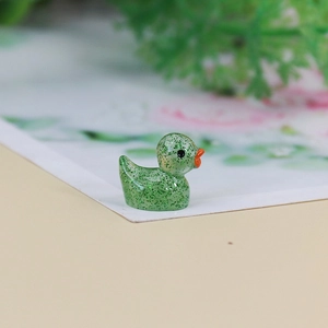 Macro view of a mini green resin duck figurine with glitter finish for micro landscapes