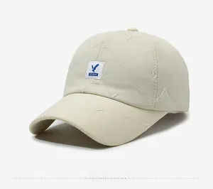 Close-up of beige quilted baseball cap featuring embroidered blue bird logo patch