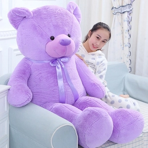 Giant light purple teddy bear plush doll with a satin bow in a cozy home setting