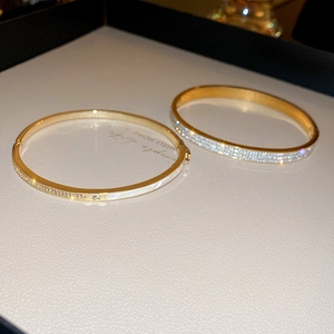 Vista macro di bracciali placcati in oro con cristalli pavé e intarsi in madreperla